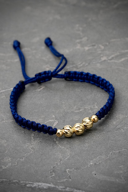 Pulsera en hilo azul con bolas diamantadas y lisas 0.75gr — Oro Amarillo
