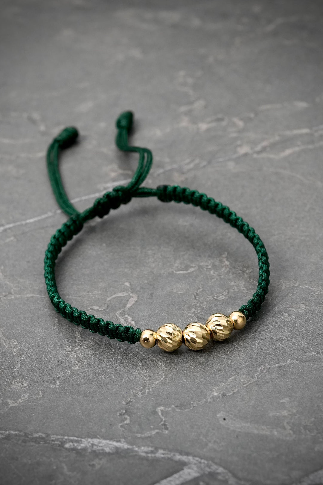 Pulsera en hilo verde con bolas diamantadas y lisas 0.75gr — Oro Amarillo