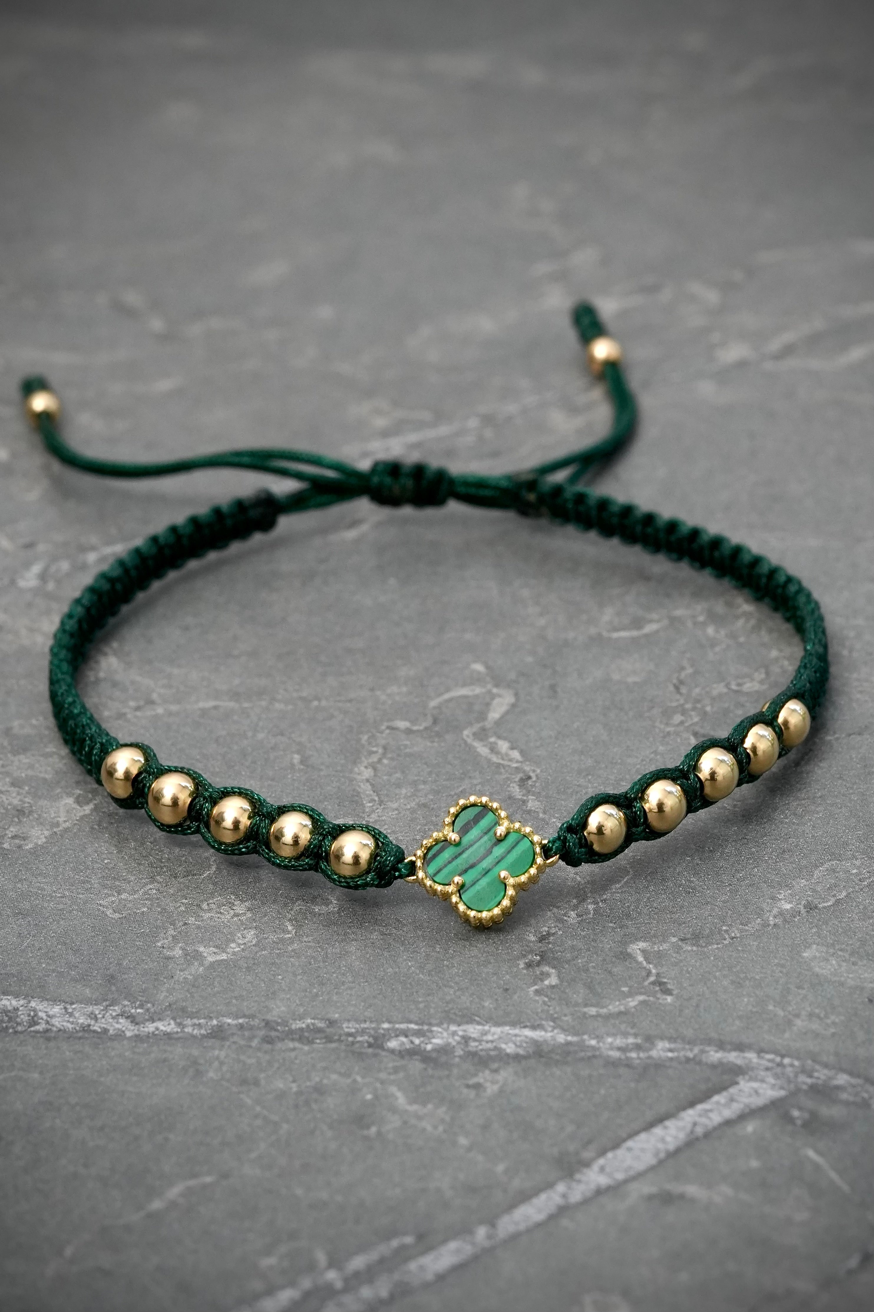 Pulsera en hilo verde con herraje lucky clover y bolas lisas 1.8gr / Oro Amarillo (Joya) M