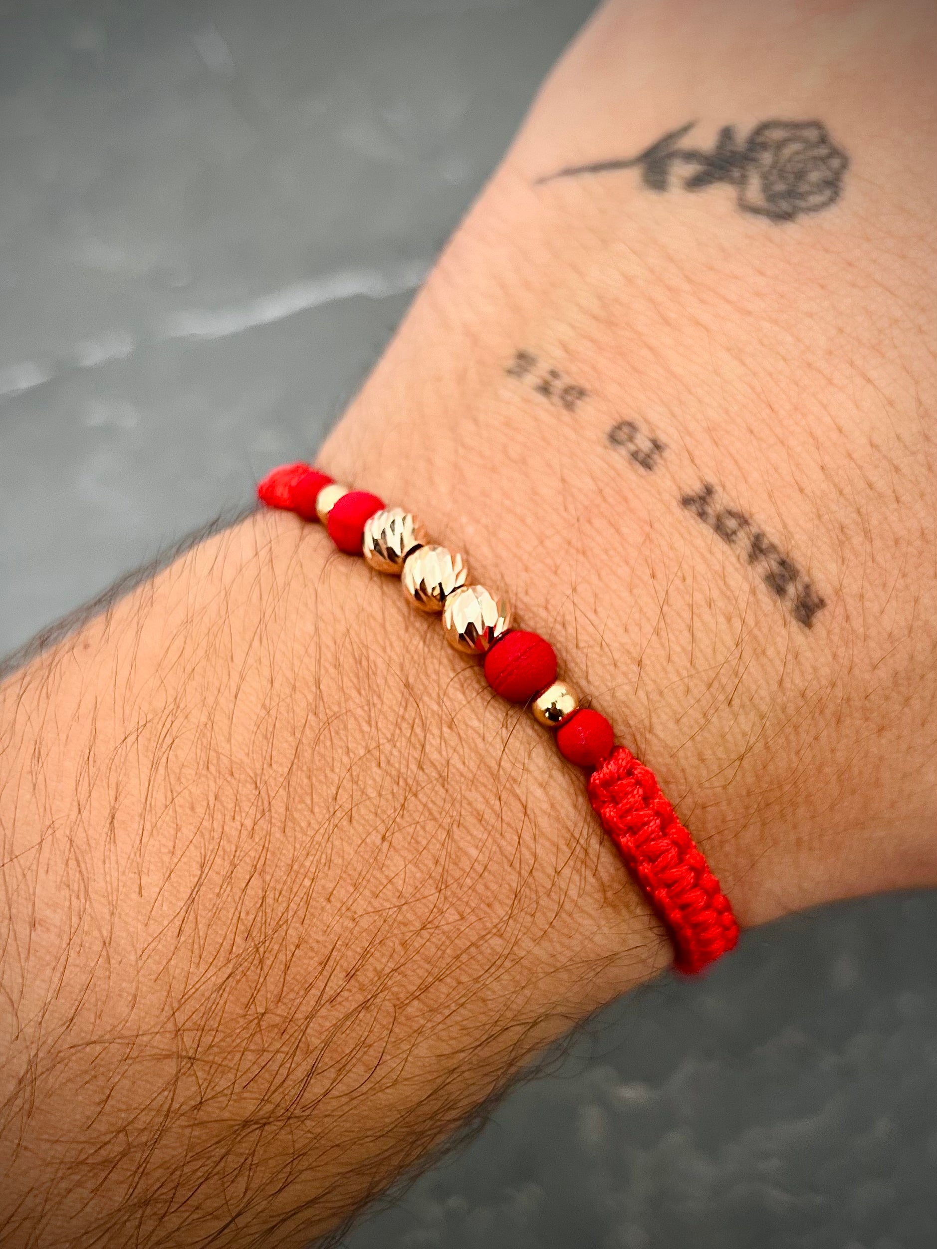 Pulsera en hilo rojo con bolas diamantadas y lisas 0.75gr / Oro Rosado (Joya) M