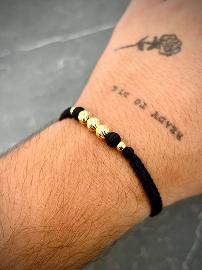 Pulsera en hilo negro con bolas diamantadas y lisas 0.75gr — Oro Amarillo