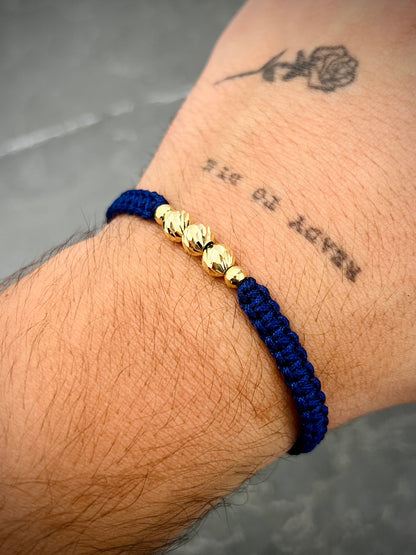 Pulsera en hilo azul con bolas diamantadas y lisas 0.75gr — Oro Amarillo