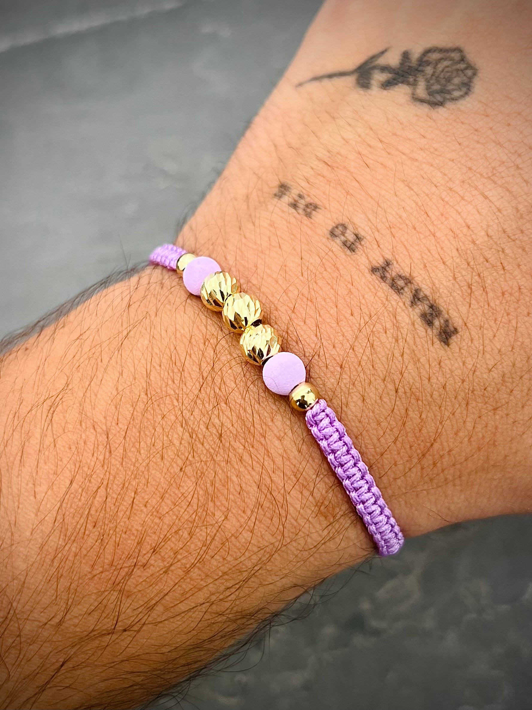Pulsera en hilo morado con bolas diamantadas y lisas 0.75gr — Oro Amarillo