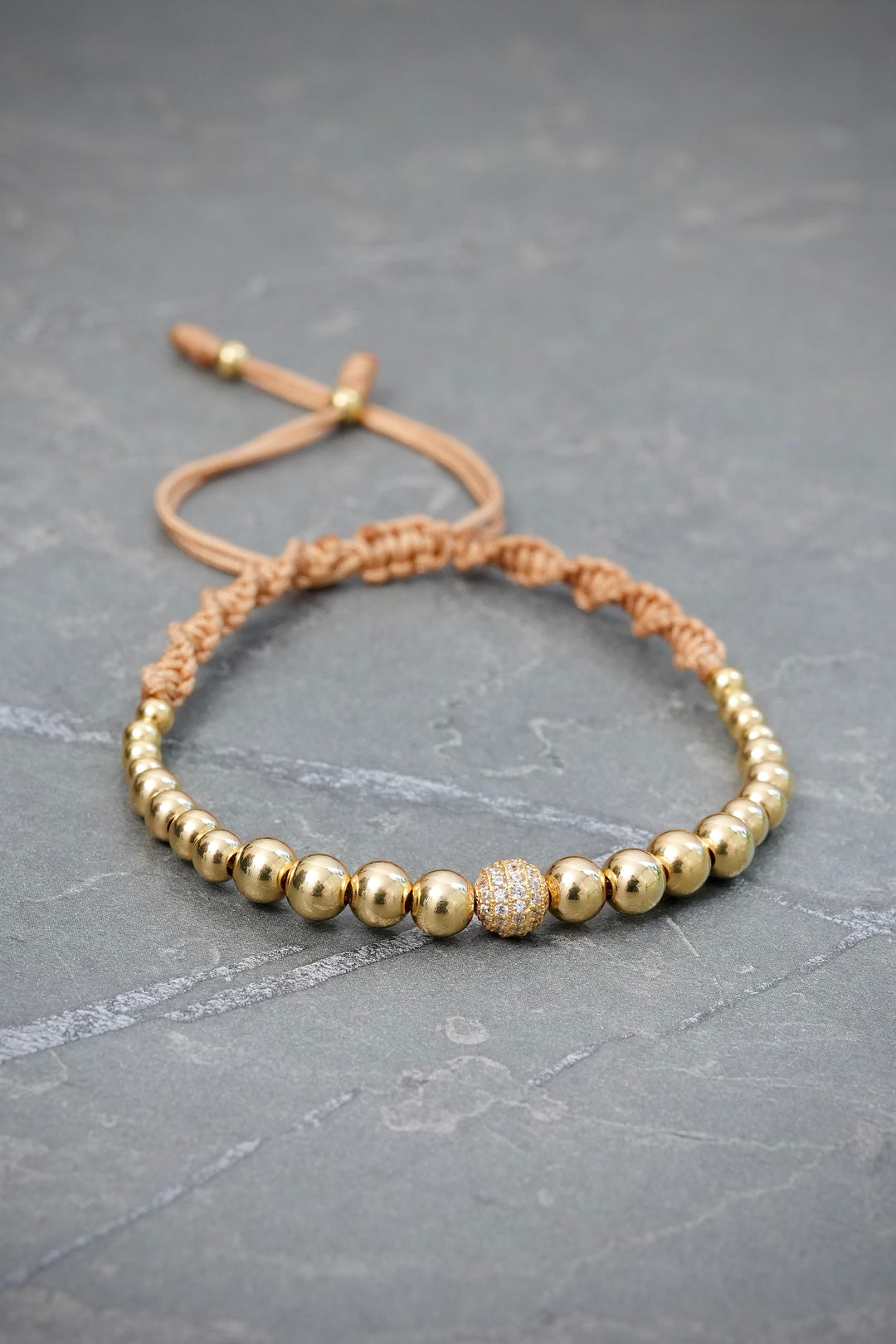 Pulsera en Hilo Beige con Bolas Lisas y Bola de Fuego 3gr — Oro Amarillo