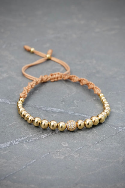 Pulsera en Hilo Beige con Bolas Lisas y Bola de Fuego 3gr — Oro Amarillo