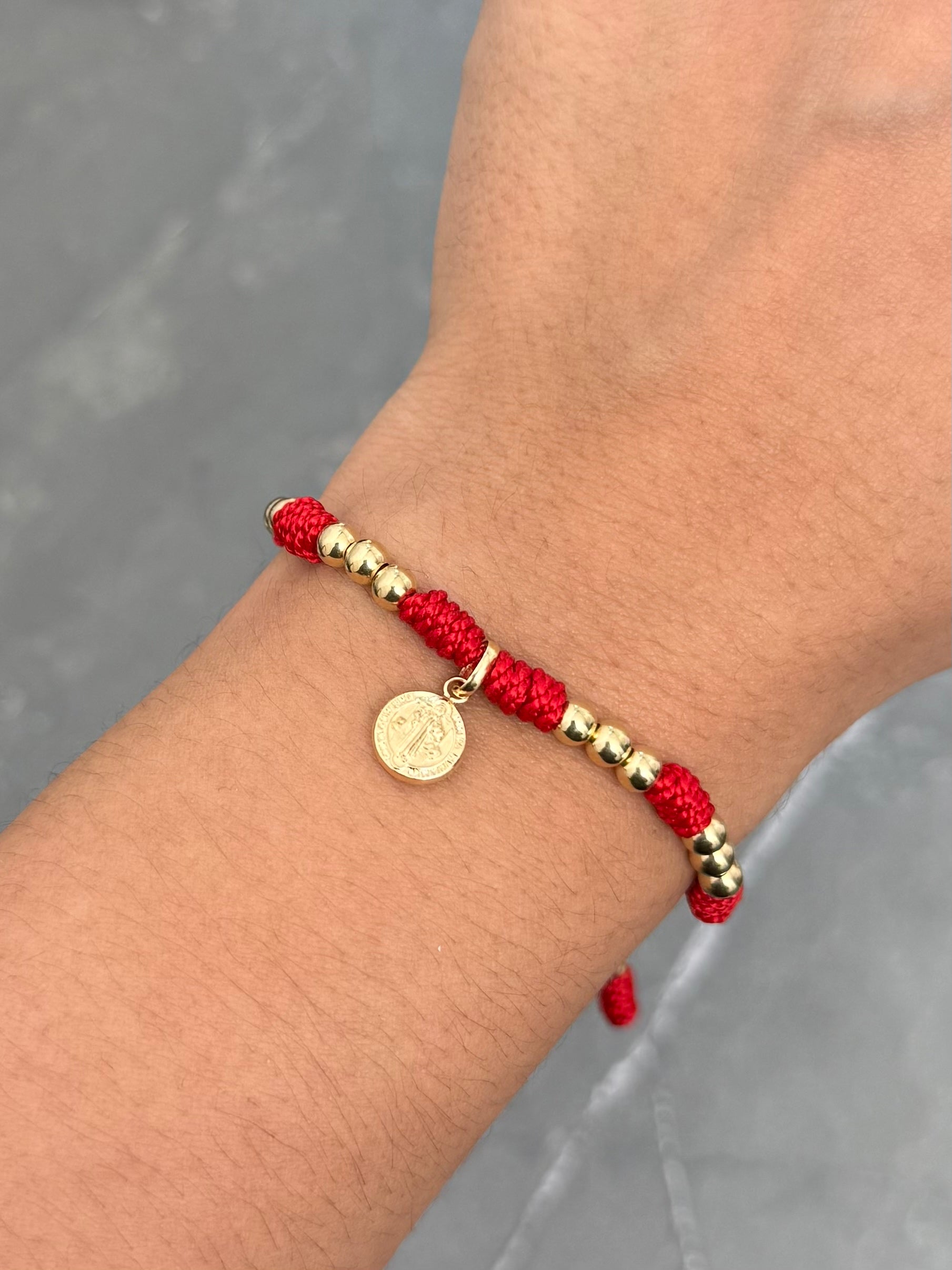 Pulsera en Hilo Rojo con Dije y Bolas Lisas 1.5gr — Oro Amarillo