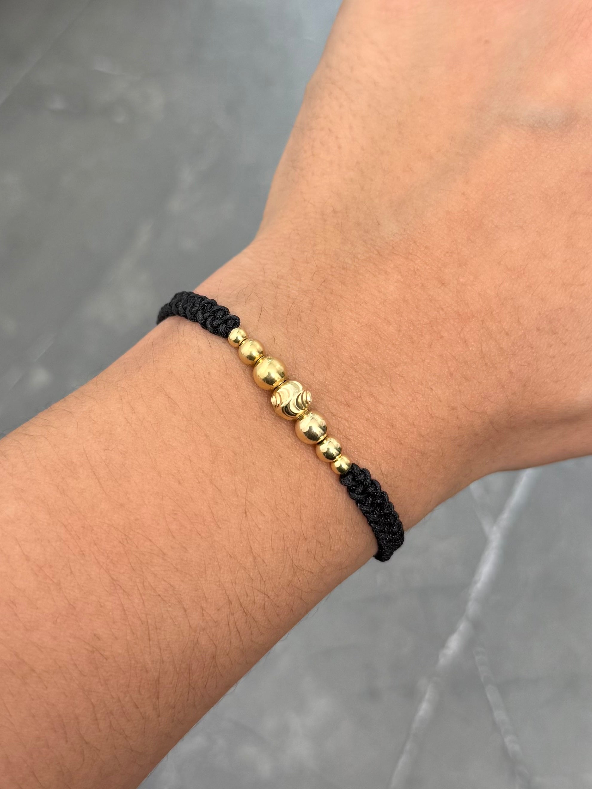 Pulsera en Hilo Negro con Bolas Lisas y Diamantada 0.95gr — Oro Amarillo