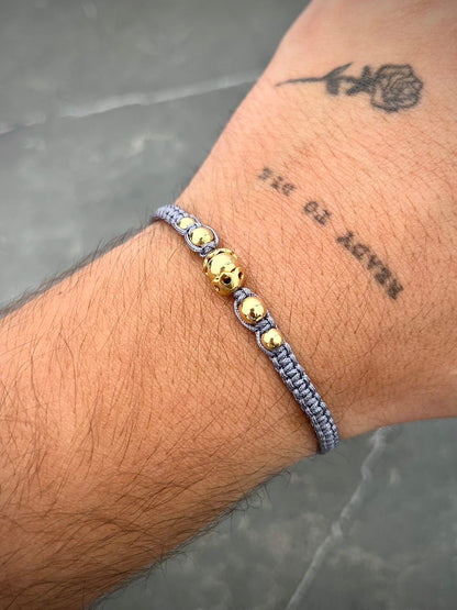 Pulsera en hilo gris con herrajes y bolas lisas 1.45gr — Oro Amarillo