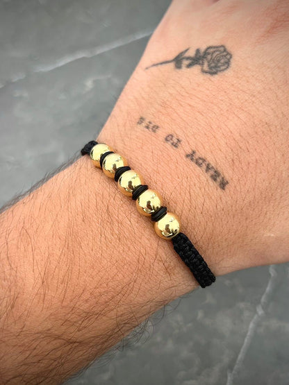 Pulsera en hilo negro con bolas lisas 1.6gr — Oro Amarillo