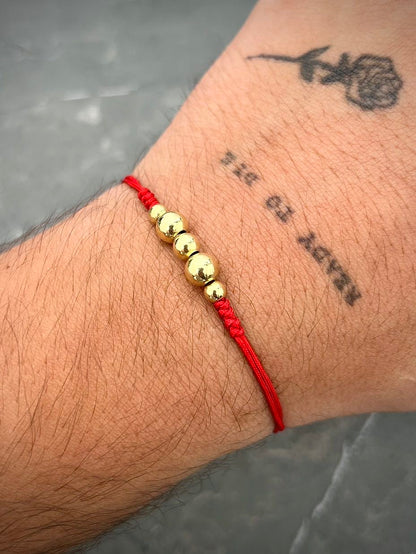 Pulsera en hilo rojo con bolas lisas 0.7gr — Oro Amarillo
