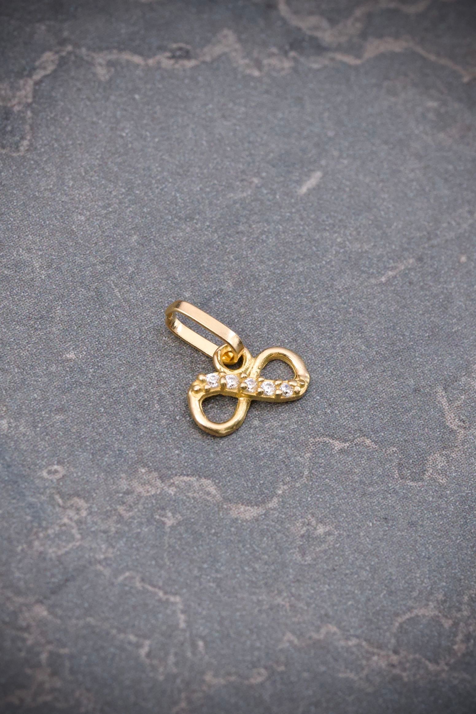 Dije infinito con swarovski blanco 0.3gr / Largo 0.9cm / Oro Amarillo Nac B