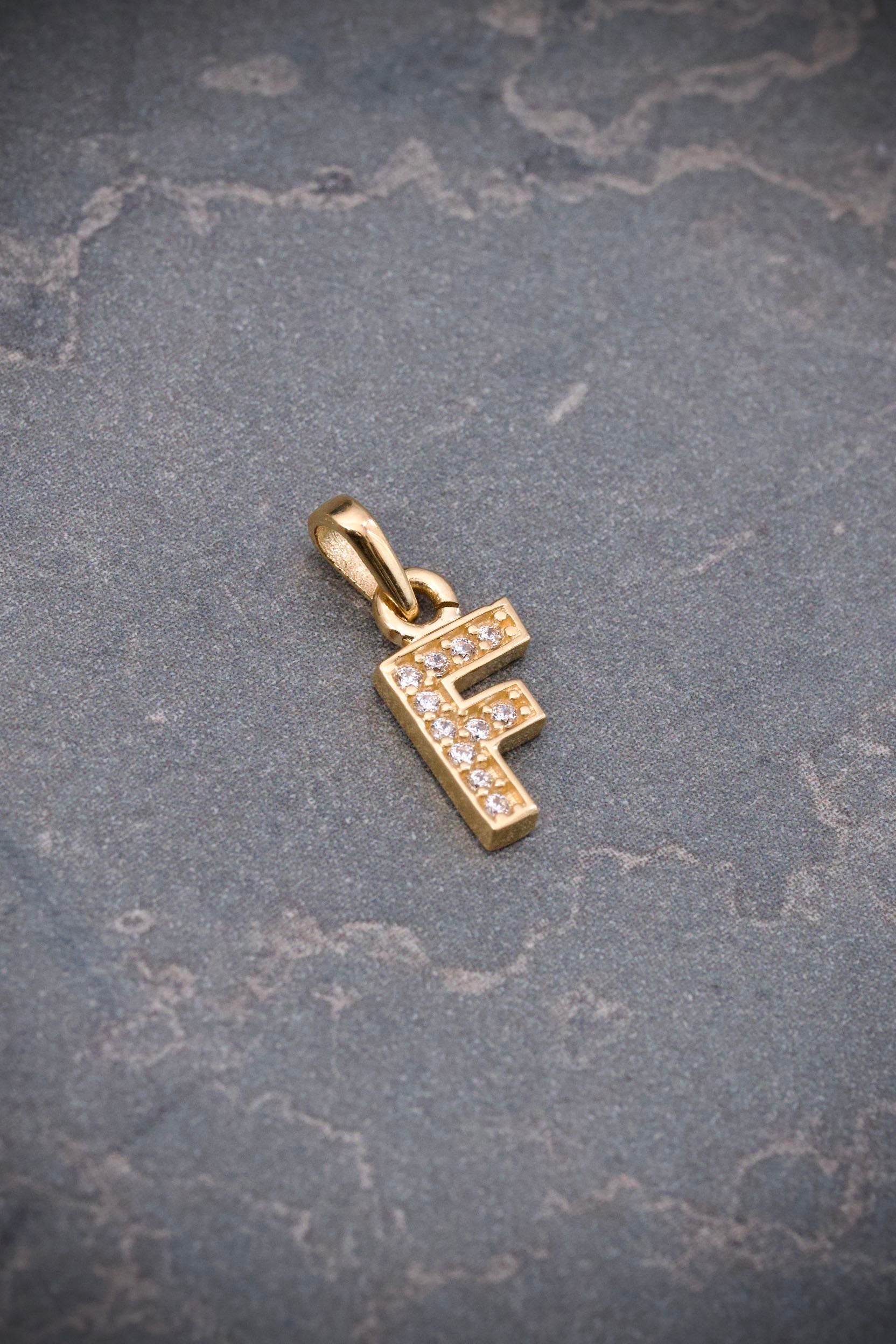 Dije letra f con swarovski blanco 0.6gr / Largo 1.4cm / Oro Amarillo Nac B