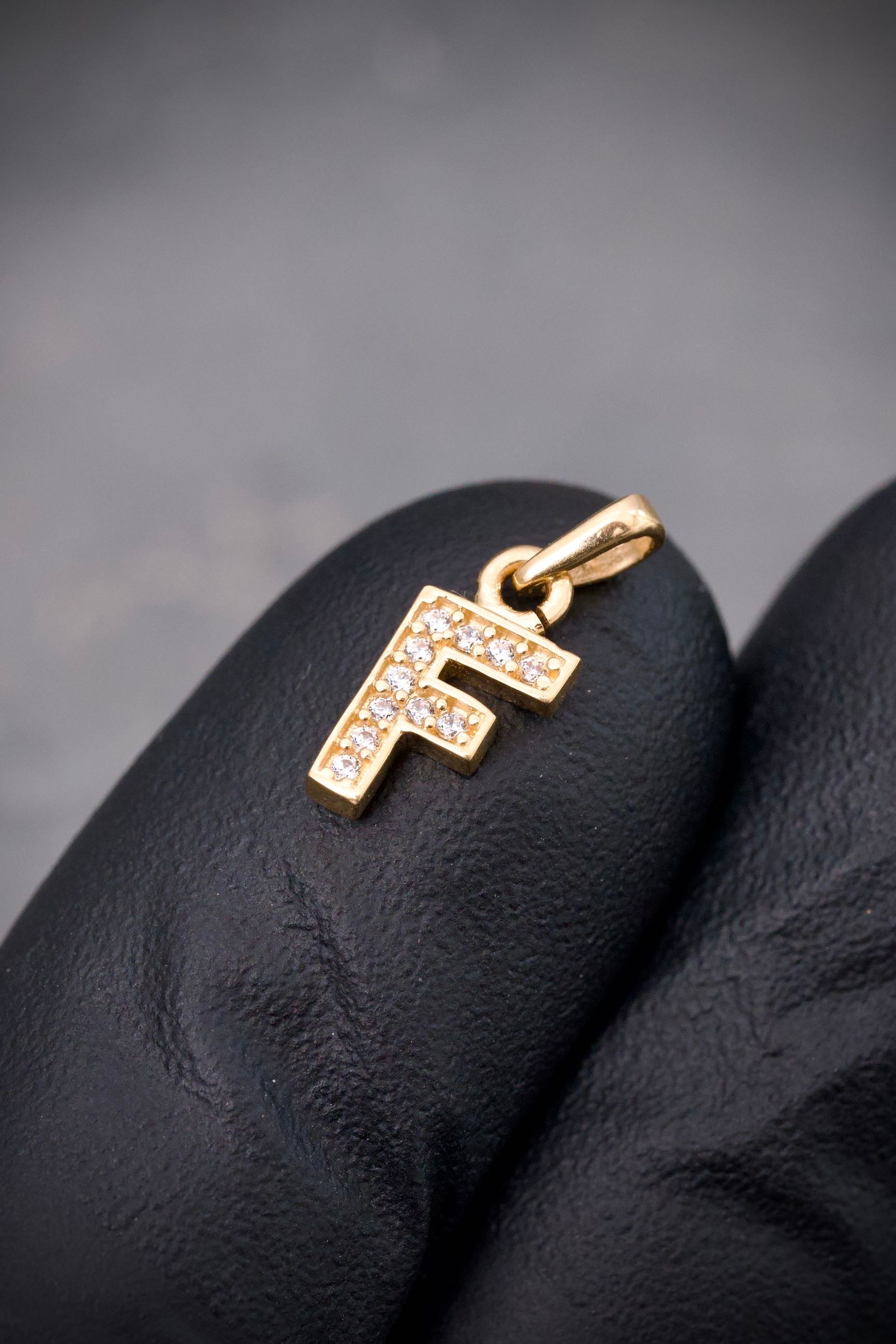 Dije letra f con swarovski blanco 0.6gr / Largo 1.4cm / Oro Amarillo Nac B