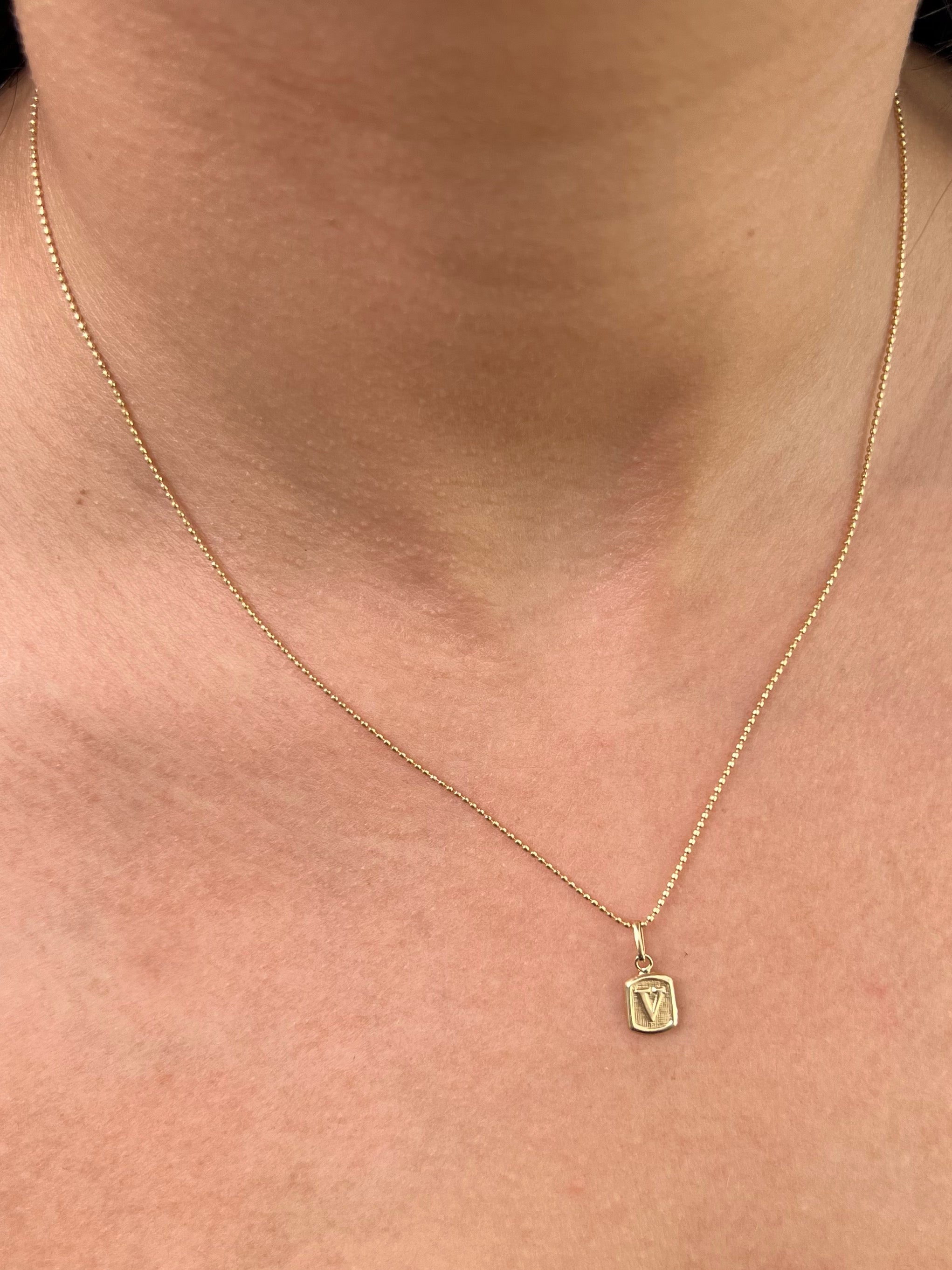 Dije letra v 0.35gr / Largo 1.5cm — Oro Amarillo