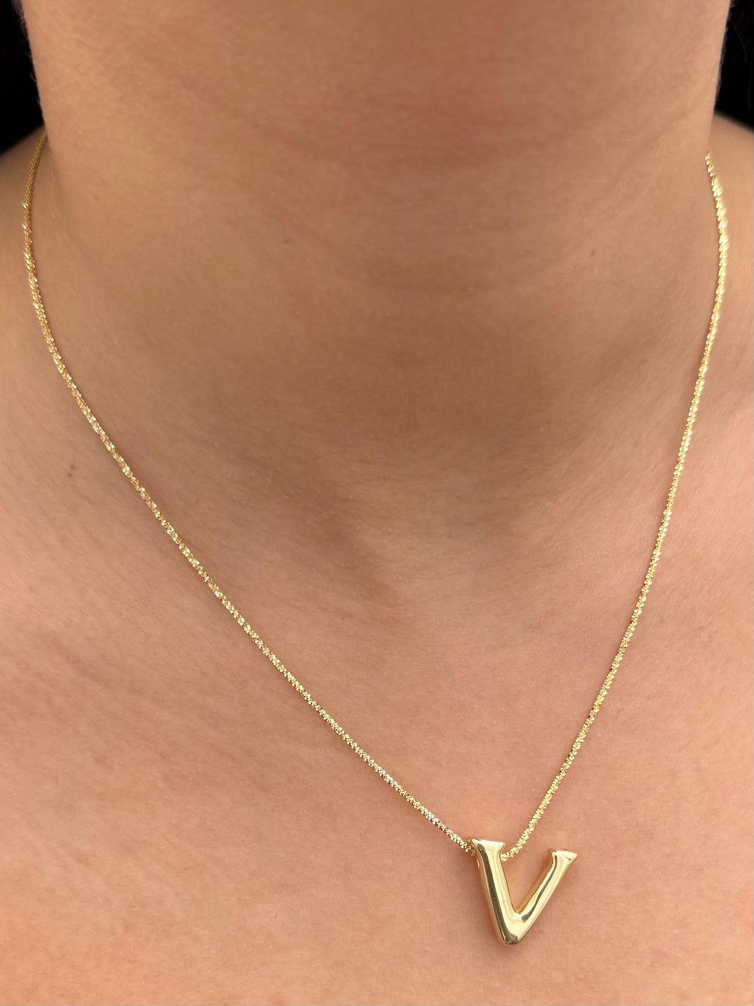 Dije letra v 0.6gr / Largo 1.7cm — Oro Amarillo